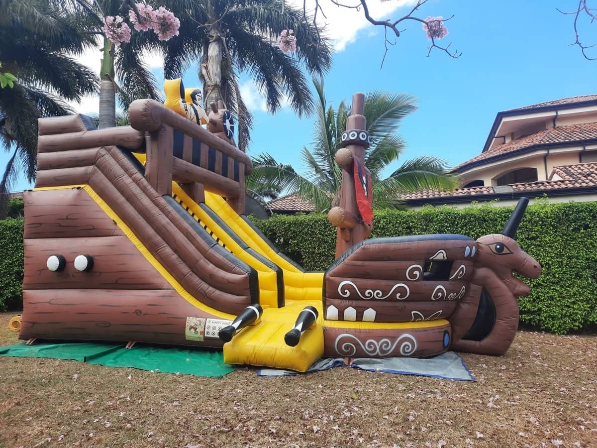 Tobogán inflable temático de barco pirata montado en un jardín